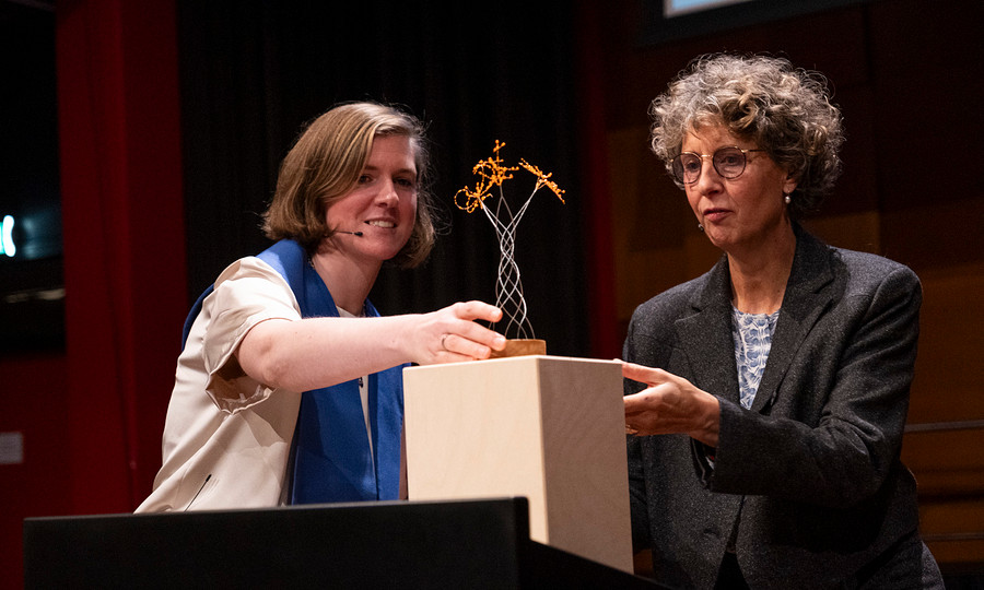 Lector Karlien Dons neemt een cadeau in ontvangst van leading dean van het Kenniscentrum Kunst & Samenleving Ingeborg Walinga