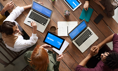 Mensen met laptops met elkaar om een tafel