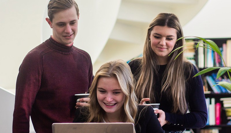 Drie studenten achter laptop 2022