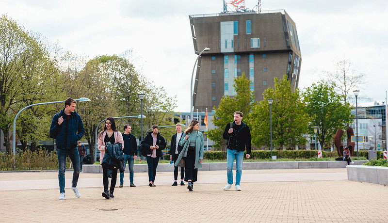 Group of students walking with Van OlstBorg in background