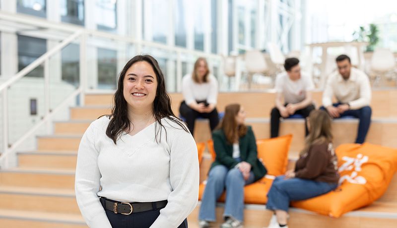 International Business student in Atrium in front of group sitting in the back.jpg