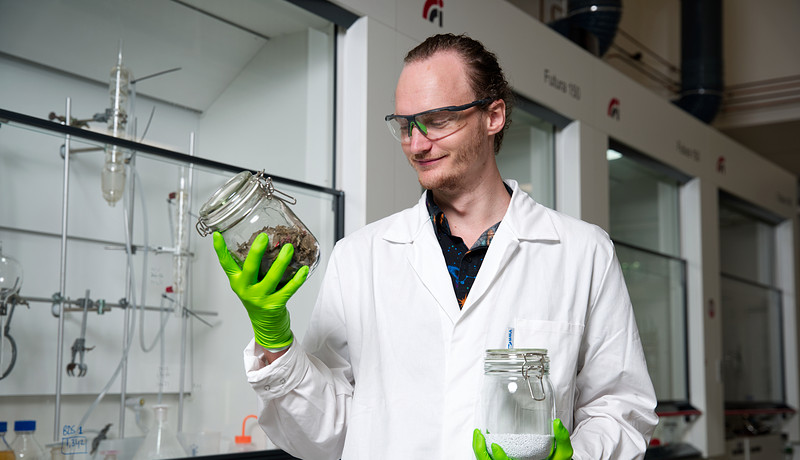 Onderzoeker Jarno houdt plastic afval vast in het lab voor het lectoraat Biobased chemistry and refinery.