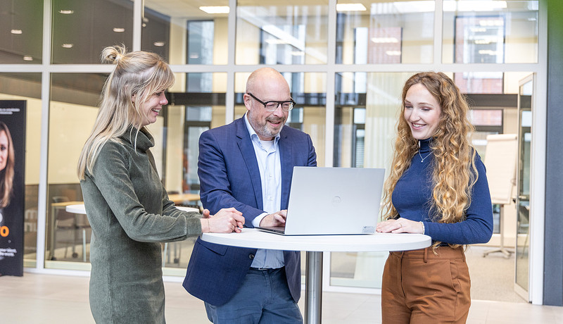 Medewerkers overleggen bij laptop 2023.jpg