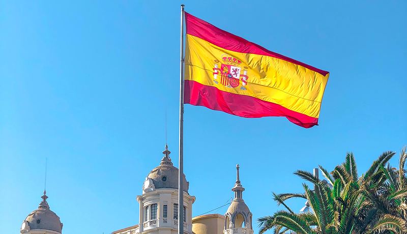 Spanish flag with building behind it