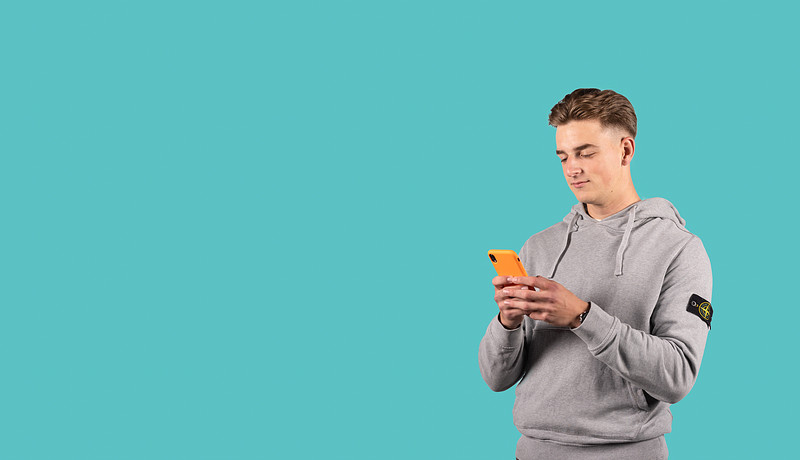 Student met oranje smartphone en grijze trui