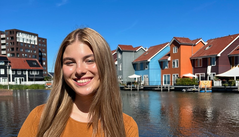 "Woman smiling in front of the colorful houses at Reitdiep in Groningen.