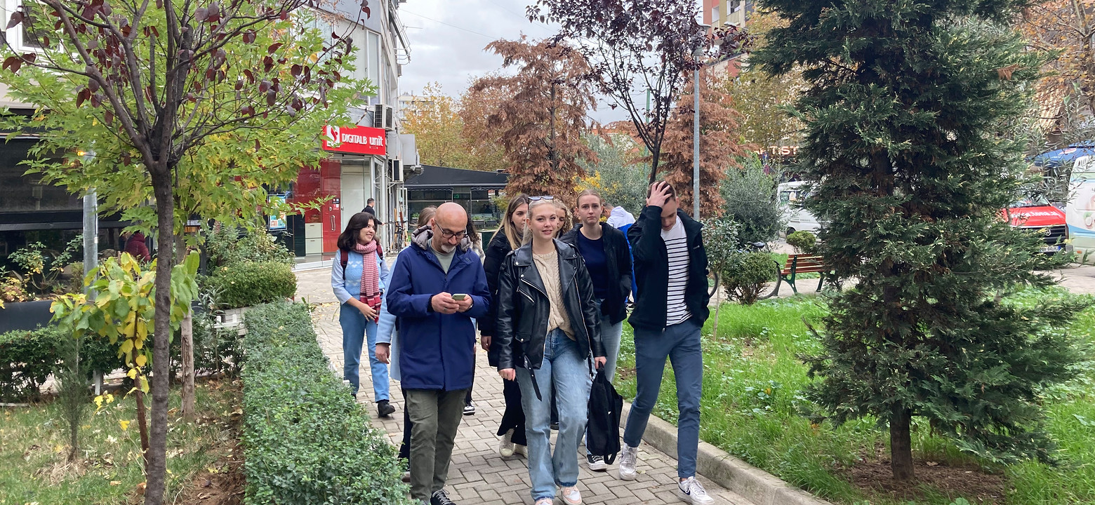 Groep loopt buiten op een pad omringd door groen.