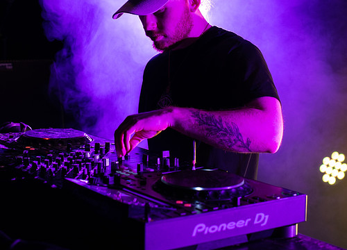 student aan draaitafel in paars licht