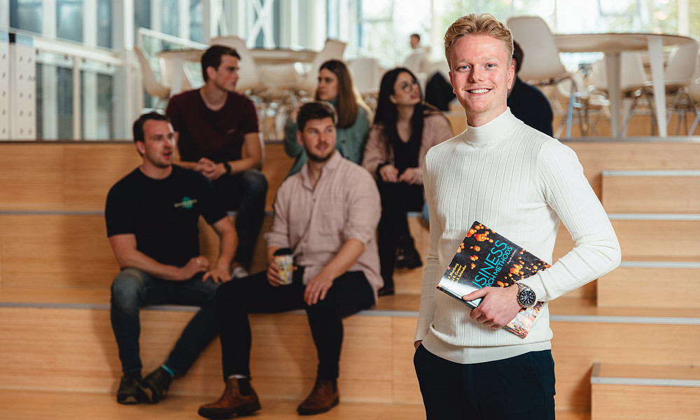 Student holding business book and looking into camera