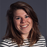Danette Schotpoort smiling and looking at the camera. She wears a striped shirt.