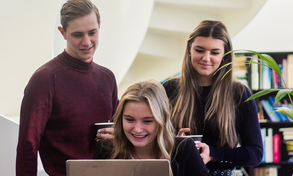 Drie studenten achter laptop 2022