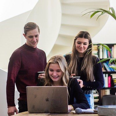 Drie studenten achter laptop 2022