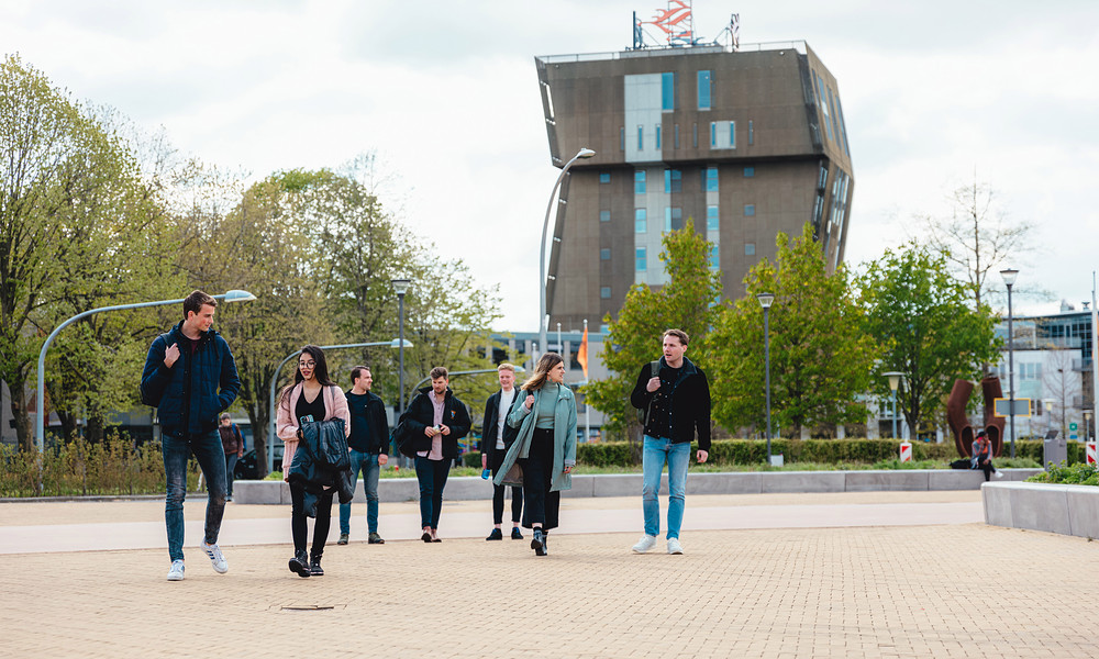 Group of students walking with Van OlstBorg in background