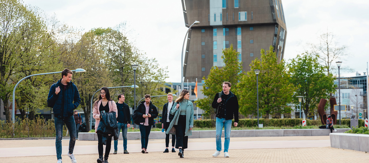 Group of students walking with Van OlstBorg in background
