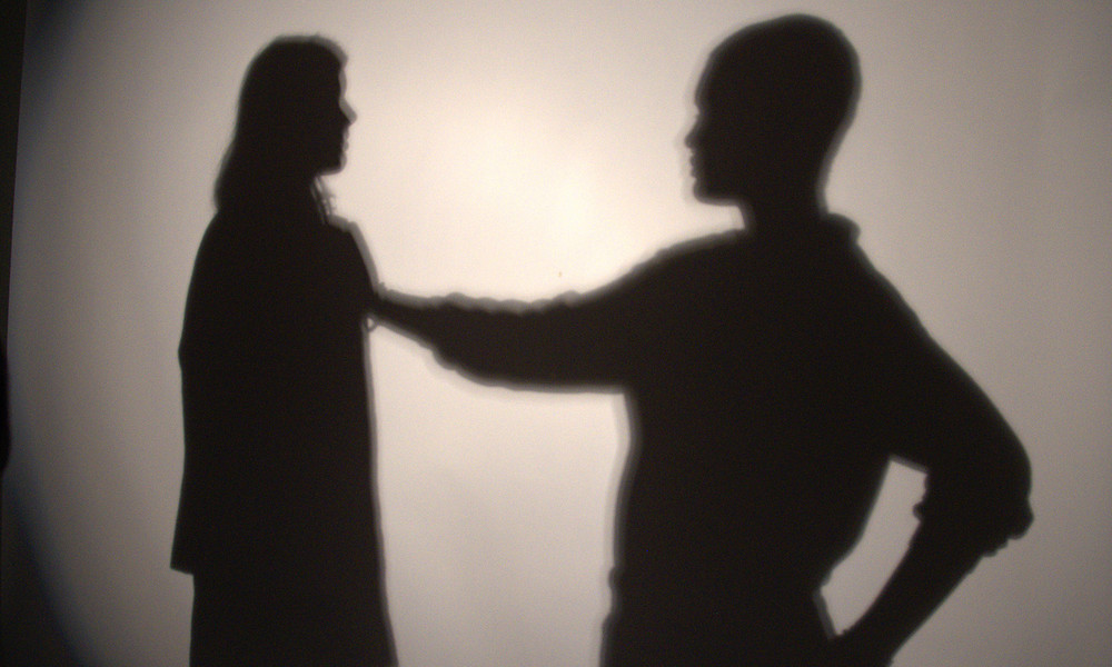 Schaduwen van twee mensen op een witte muur