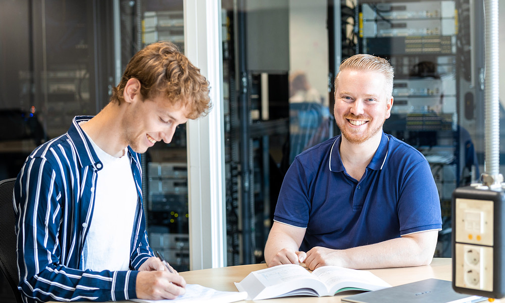 Twee studenten aan tafel HBO-ICT