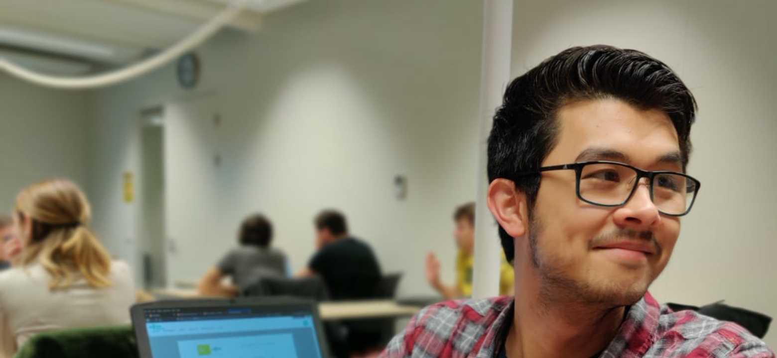 Timothy looking over his shoulder to discuss a project with a classmate.