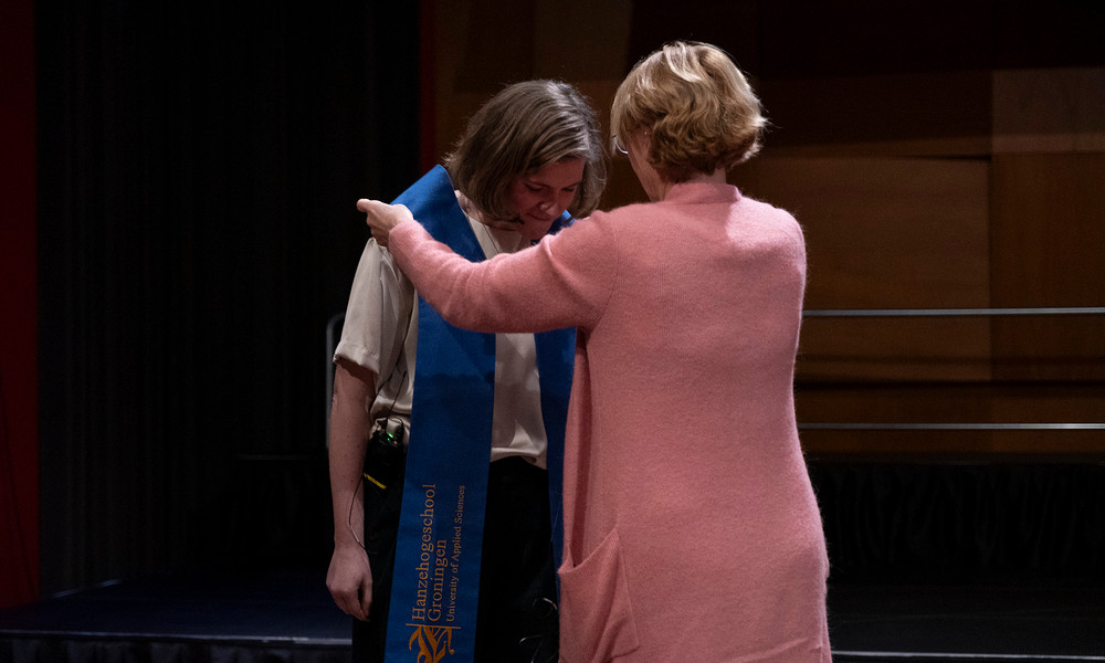 Lector Karolien Dons krijgt een sjerp omgehangen door lid van het College van Bestuur Annemarie Hannink