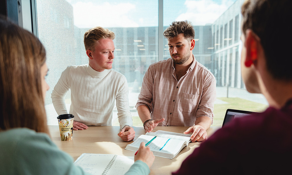 Students sitting at table discussing document