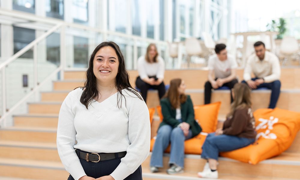 International Business student in Atrium in front of group sitting in the back.jpg