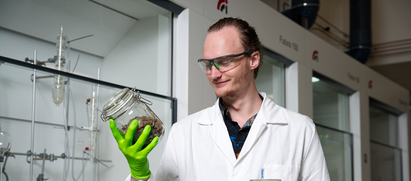 Onderzoeker Jarno houdt plastic afval vast in het lab voor het lectoraat Biobased chemistry and refinery.