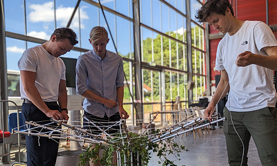 Onderzoeker Niels Kuijpens en twee studenten werken aan een prototype van de Klimaatboom