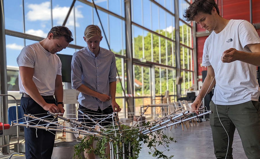 Onderzoeker Niels Kuijpens en twee studenten werken aan een prototype van de Klimaatboom