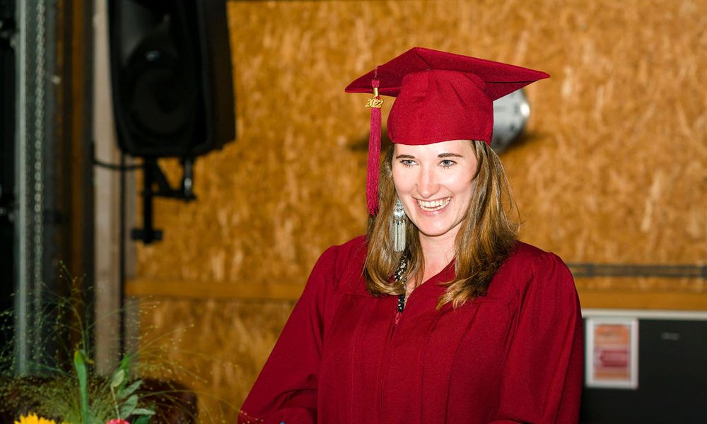 MSc in Business Studies student Kyra Bär wearing red cap and gown at graduation