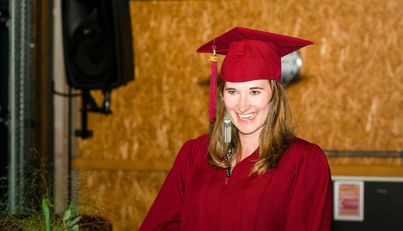MSc in Business Studies student Kyra Bär wearing red cap and gown at graduation