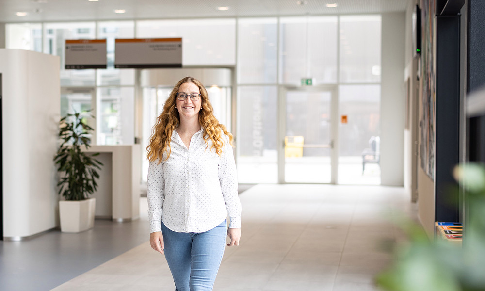 MSc in Business Studies alumna Marie Bruns-Strenge walking towards camera in A-wing Van OlstBorg