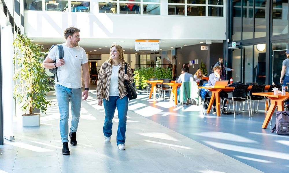 Studenten Erik en Evelien lopen door de gang