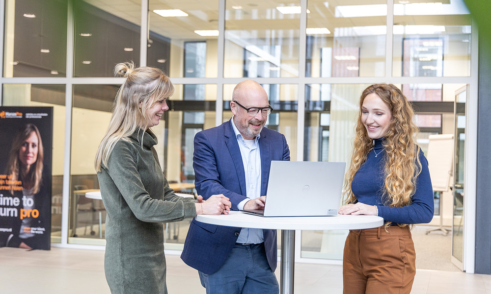 Medewerkers overleggen bij laptop 2023 klein.jpg