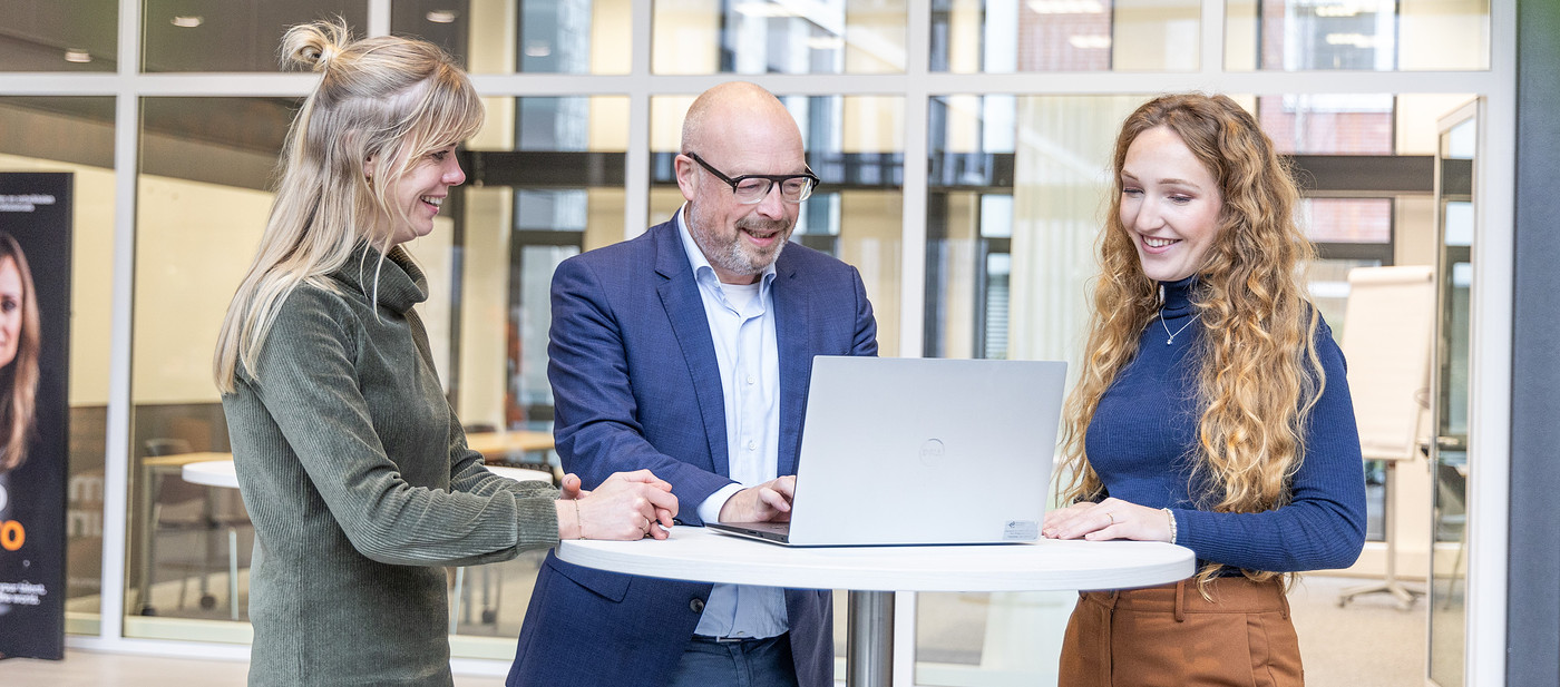 Medewerkers overleggen bij laptop 2023.jpg