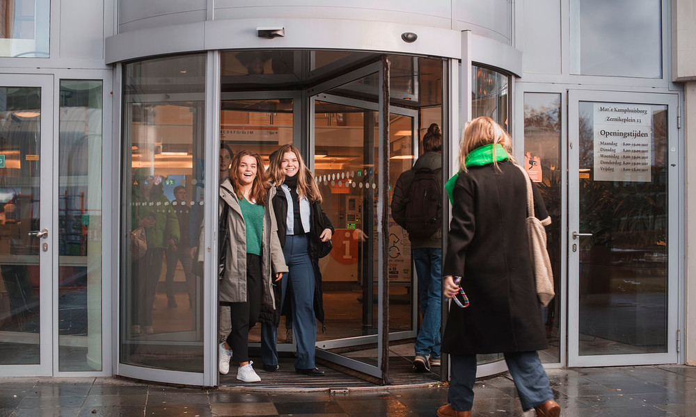2 studenten lopen de deur uit