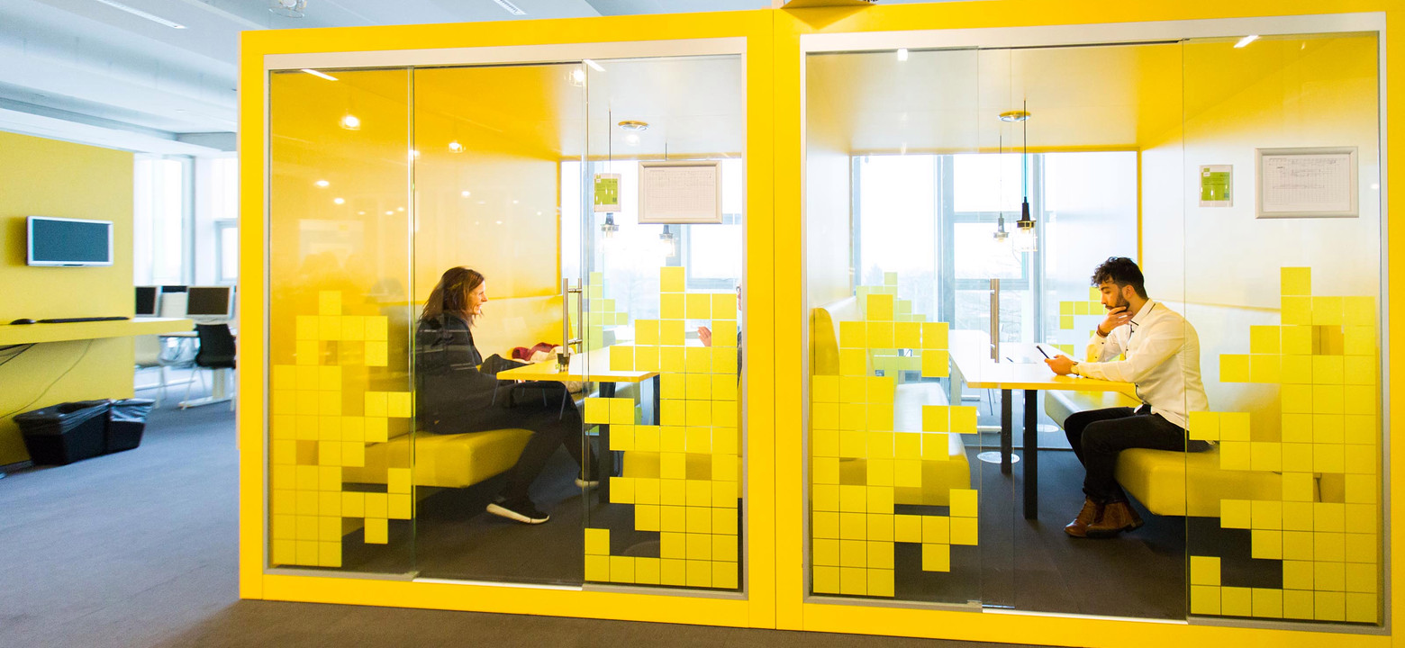 Twee studenten opleiding Bedrijfskunde Saxion aan het werk in gele kubus