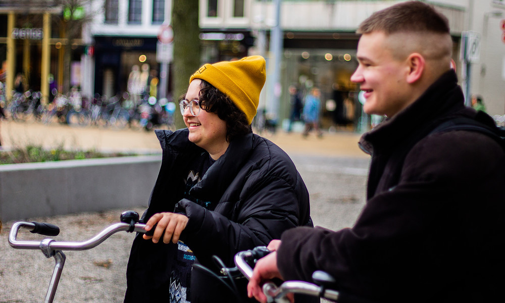 Student met gele muts en fiets in stad 2022.jpg