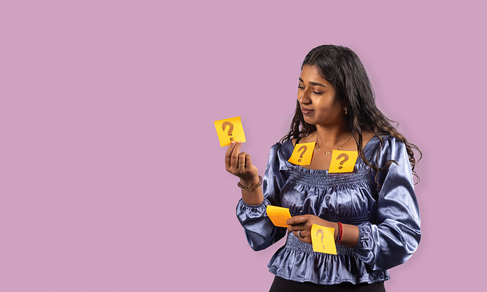 Student met oranje post its met hierop vraagtekens