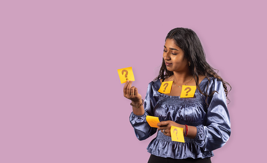Student met oranje post its met hierop vraagtekens