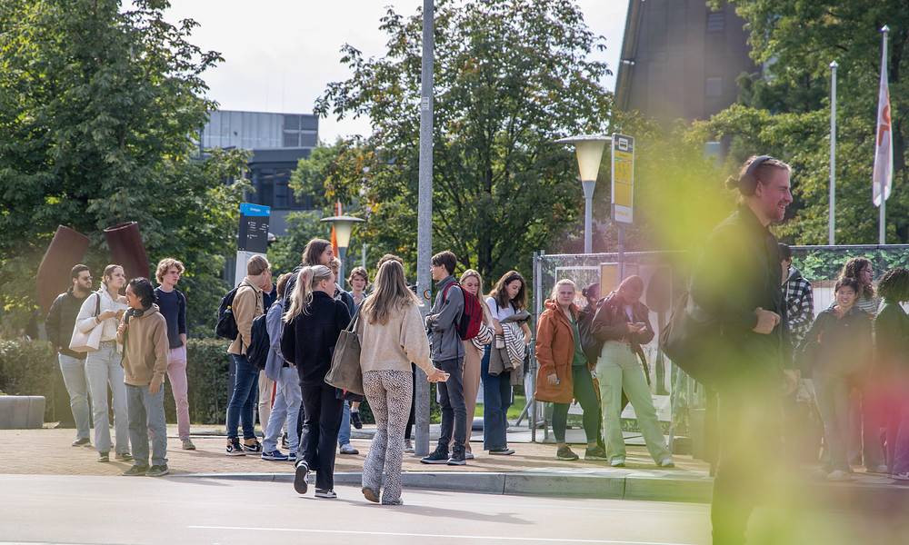 Studenten bij bushalte op campus 2023.jpg
