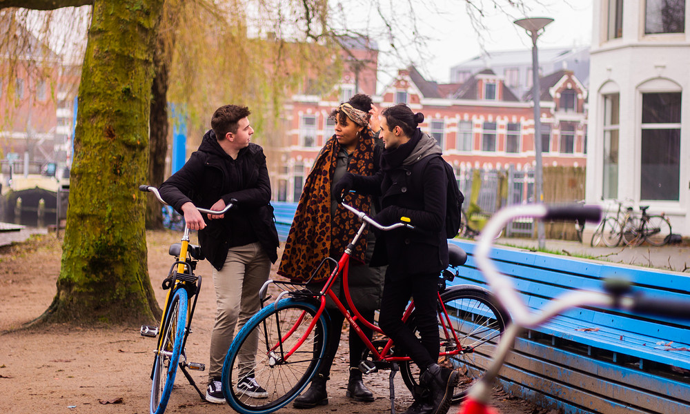 Studenten in gesprek bij blauw bankje in stad Groningen 2022