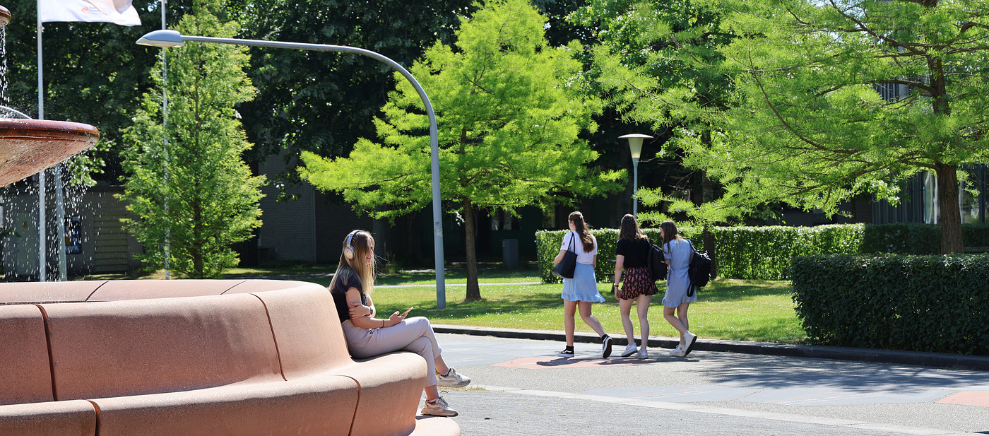 Studenten lopen en zitten bij fontein zomer 2023.JPG