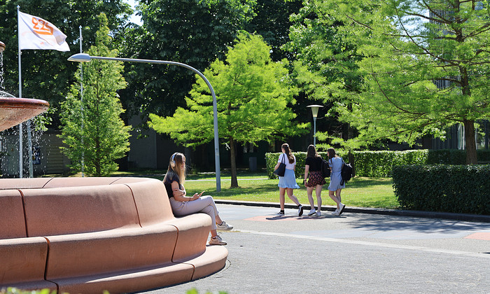 Studenten lopen en zitten bij fontein zomer 2023.JPG