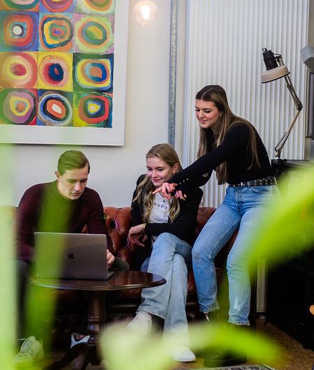 Studierende schauen auf einen Laptop
