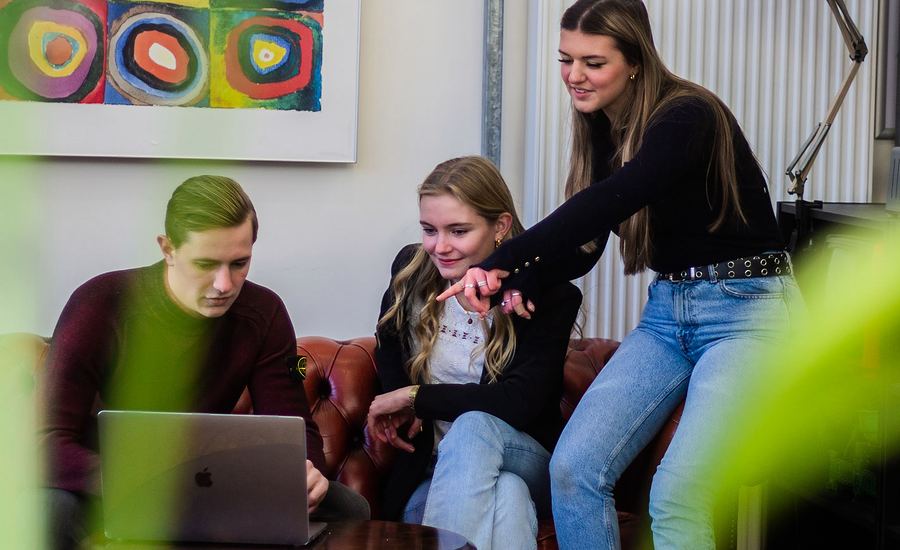 Studierende schauen auf einen Laptop