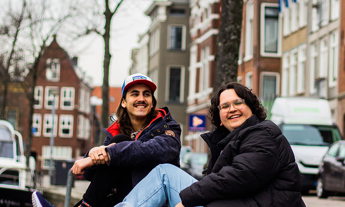 Studenten zitten aan de gracht in stad Groningen