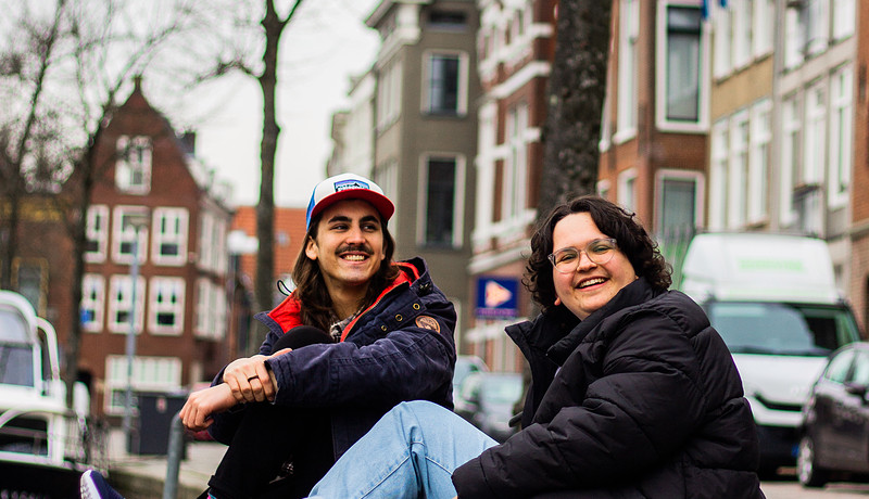 Studenten zitten aan de gracht in stad Groningen