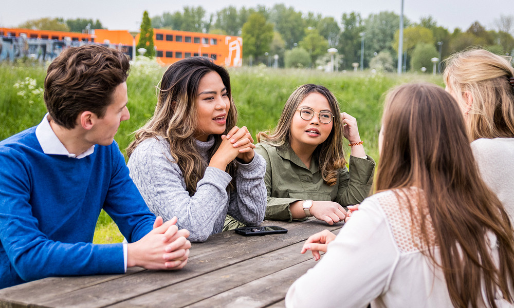 Students at picknick table near container buildings.jpg