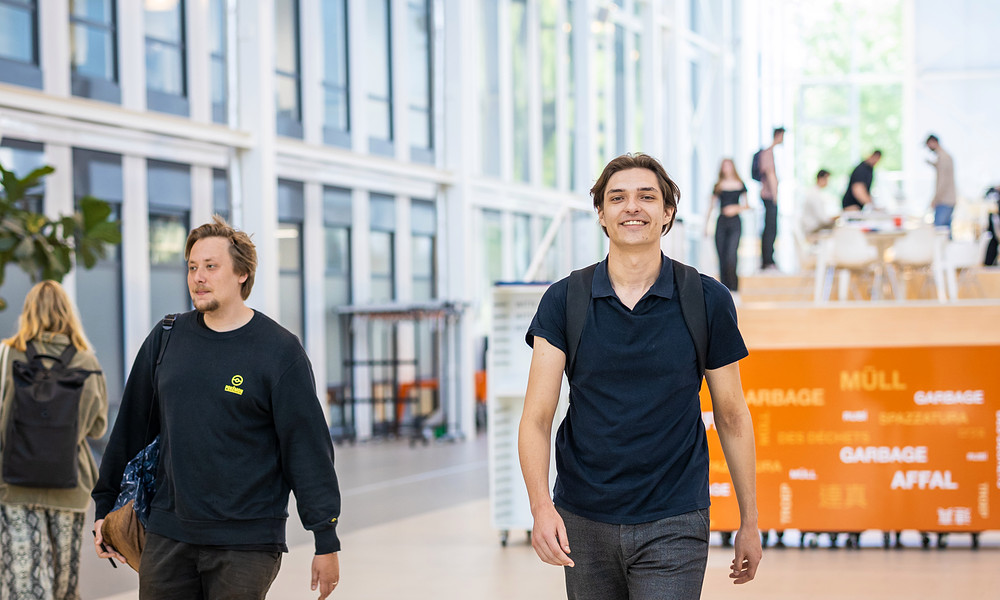 IBS students Pim and Thyme walking towards camera in Atrium on Zernike campus