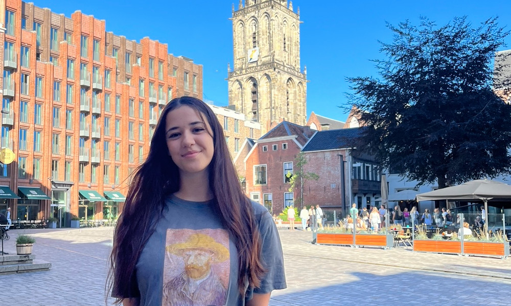 Woman smiling in front of the Martini Tower in Groningen.