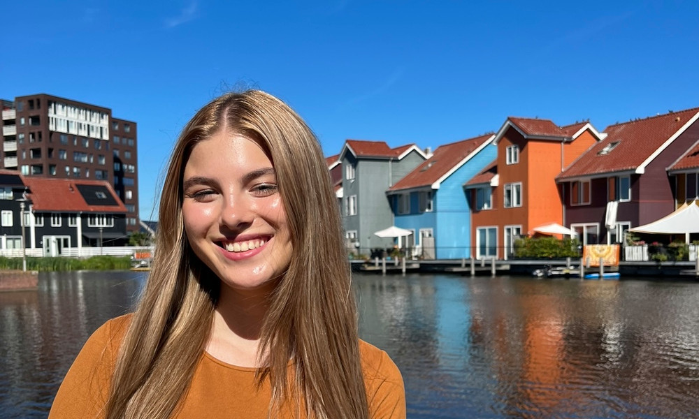 "Woman smiling in front of the colorful houses at Reitdiep in Groningen.